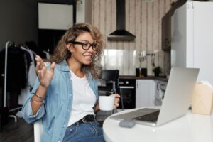 heimwee na verhuizen. hou contact met vrienden en familie. Foto van vrouw met koffie die videocall doet